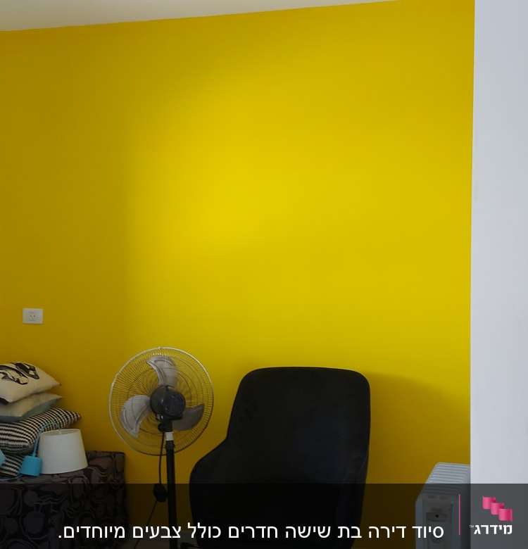 קיר צבוע בצהוב עם חפצים בחדר